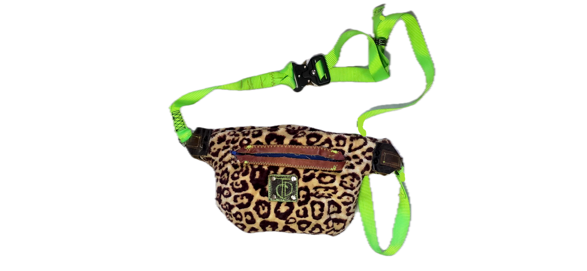 A leopard print dog harness bag with a bright neon green adjustable strap and collar, shown on a plain white background.